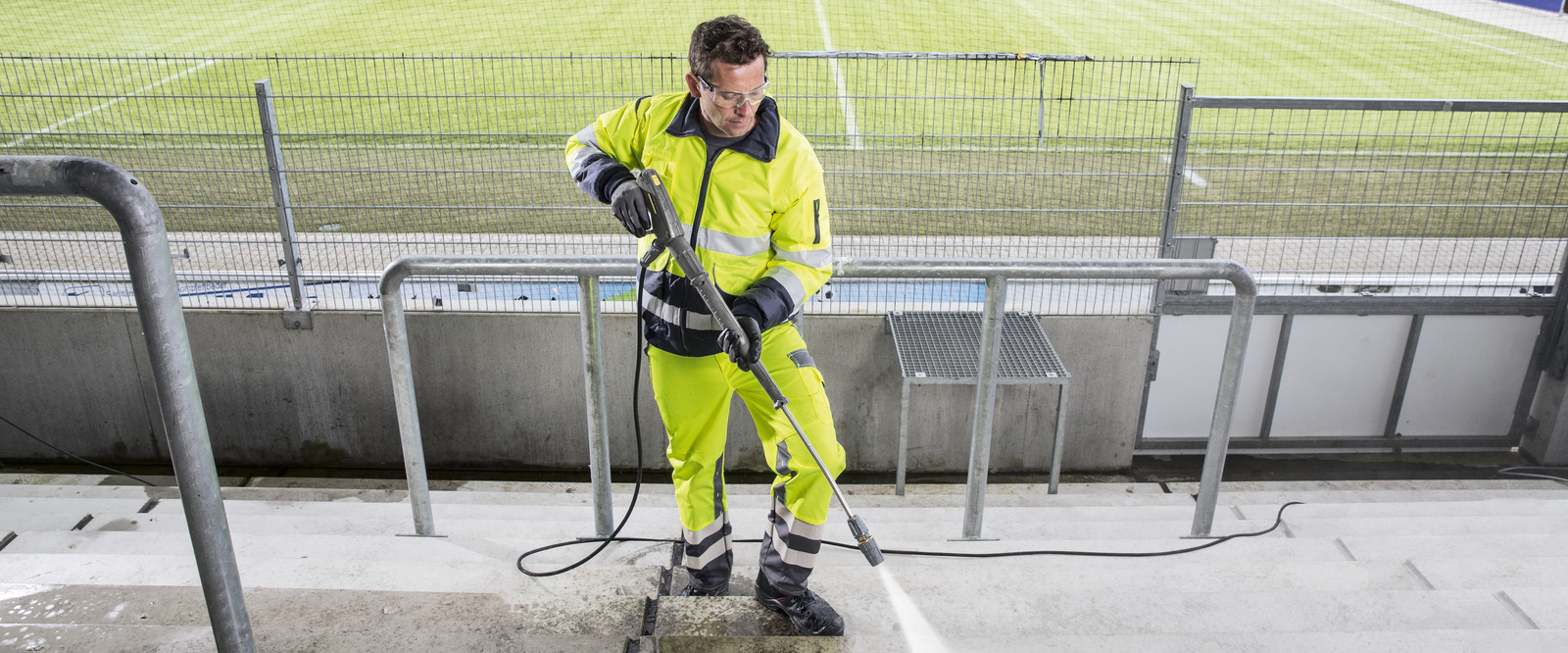 High pressure cleaner in use A man cleaning a grandstand with a high pressure cleaner