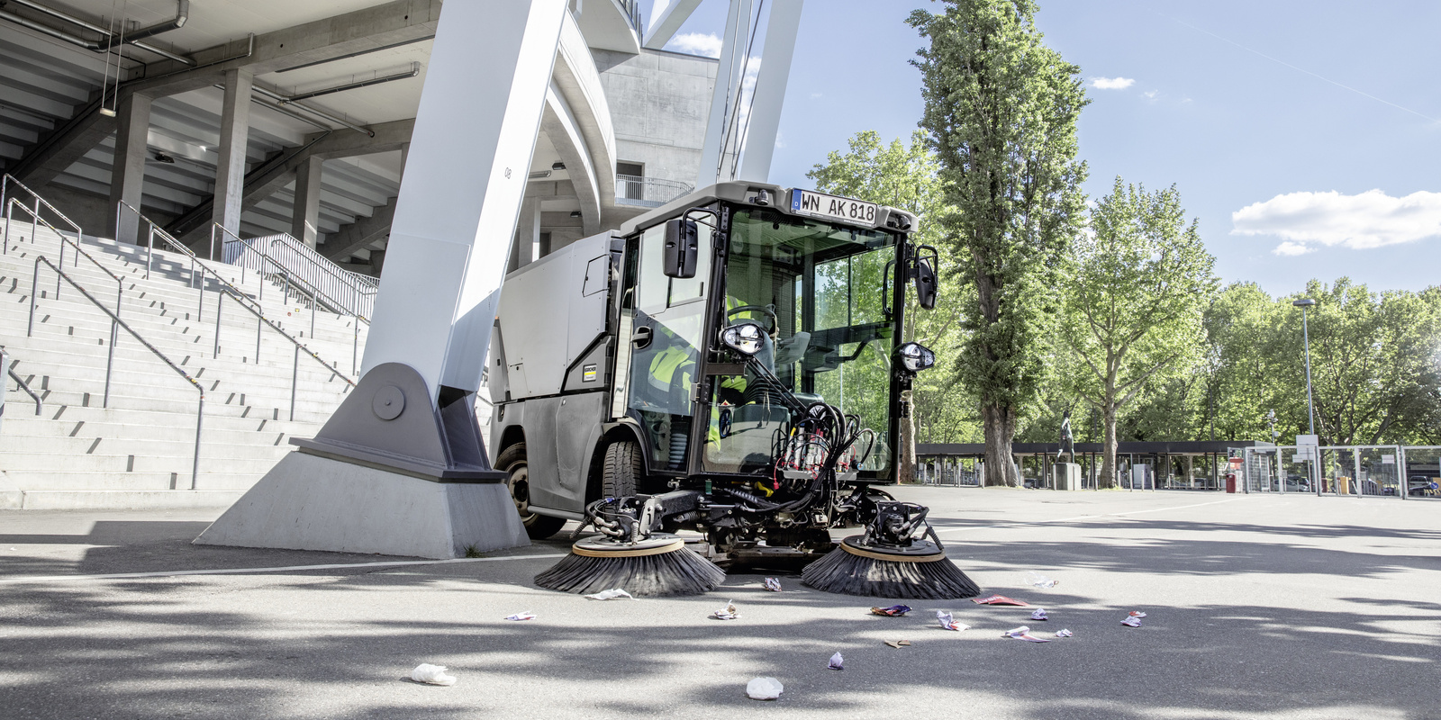 Sweeper in use A man cleaning an outdoor area with a Kärcher sweeper