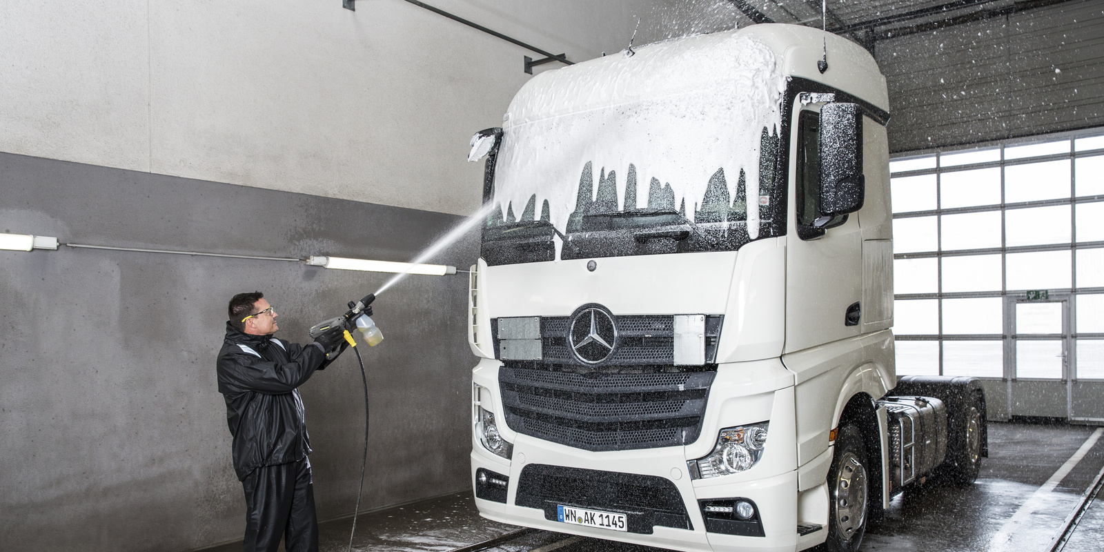 Truck cleaning with cleaning concentrate A person spraying a truck with cleaning concentrate