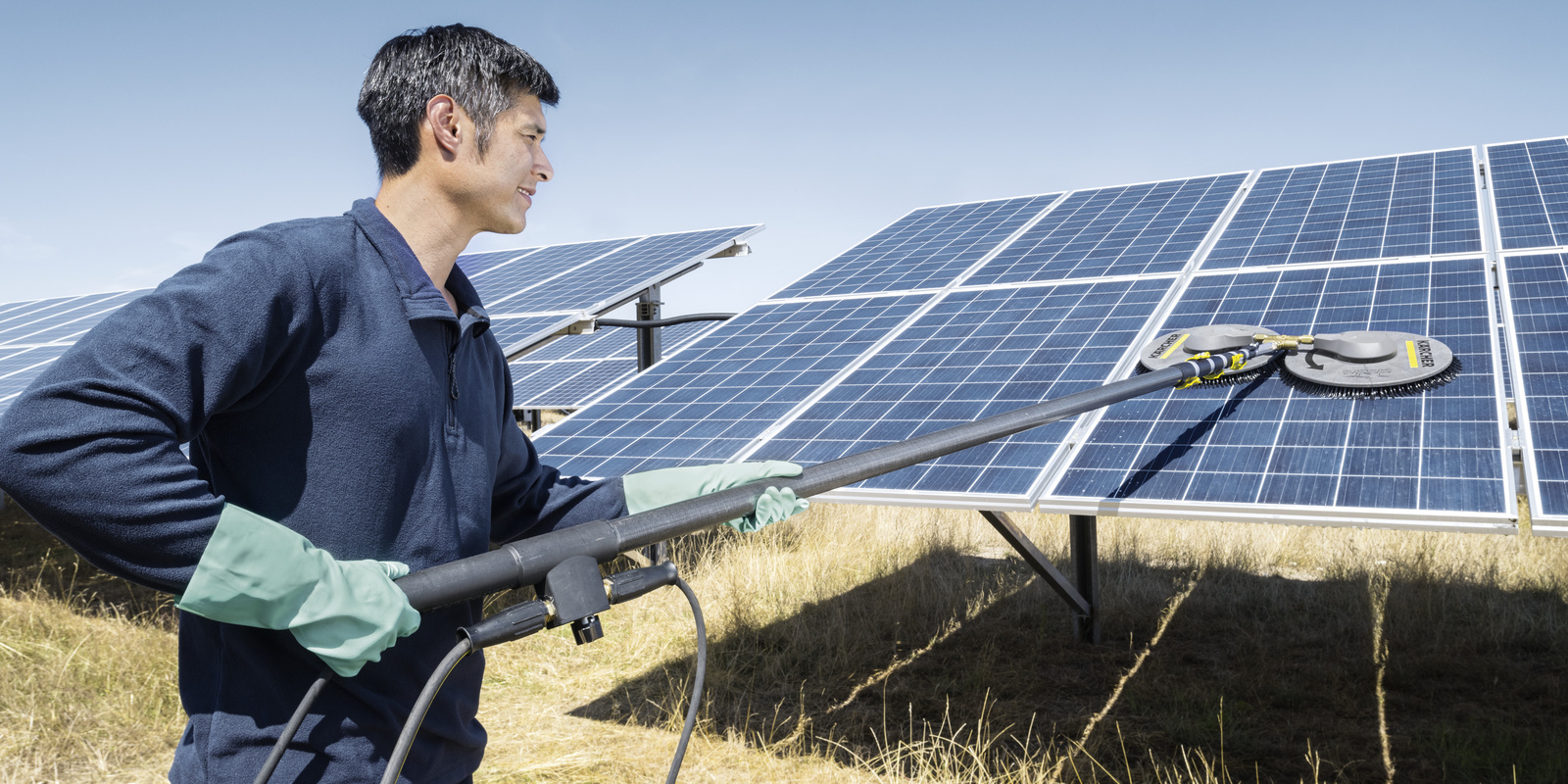 Cleaning of photovoltaic systems A man cleaning photovoltaic systems with a Kärcher cleaning system