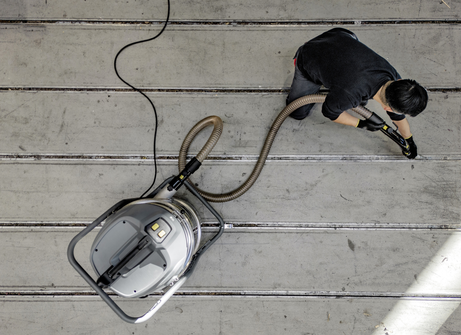 Industrial vacuum cleaner in use A man removes dust from a floor using a Kärcher industrial vacuum cleaner