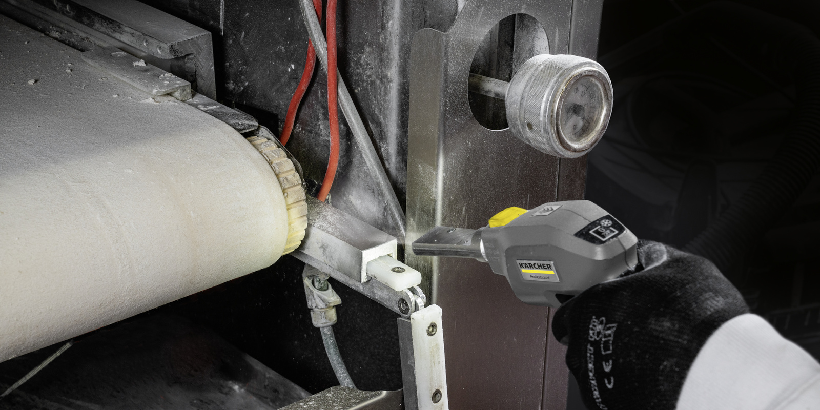 Dry ice cleaning A transport belt is cleaned with a dry ice blaster