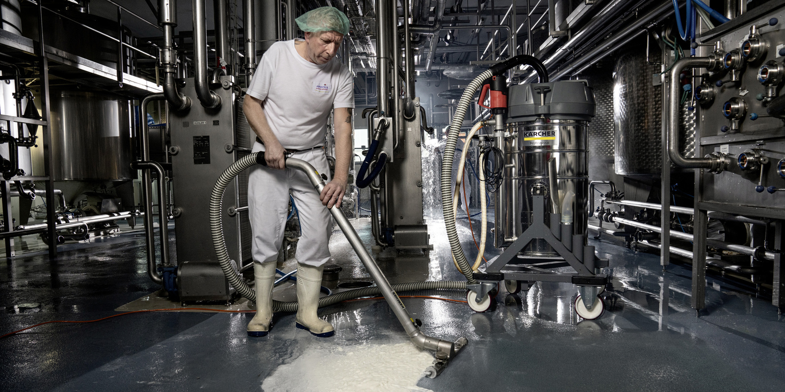 Floor cleaning with the industrial vacuum cleaner A man vacuums the floor with the industrial vacuum cleaner