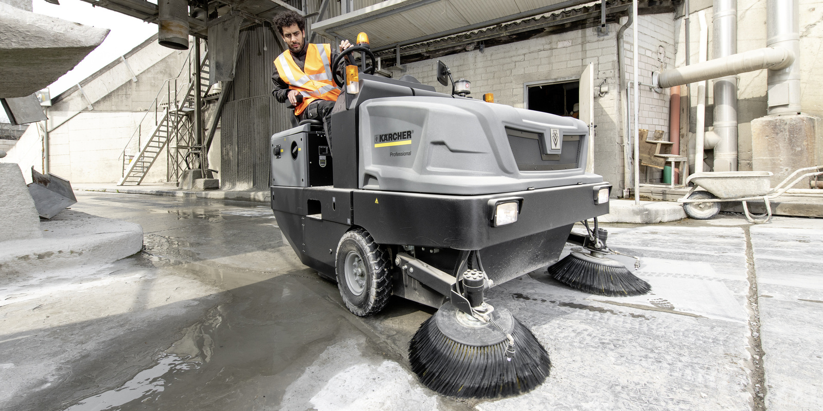 Effective surface cleaning with the Kärcher industrial sweeper A man cleans the floor with a Kärcher industrial sweeper