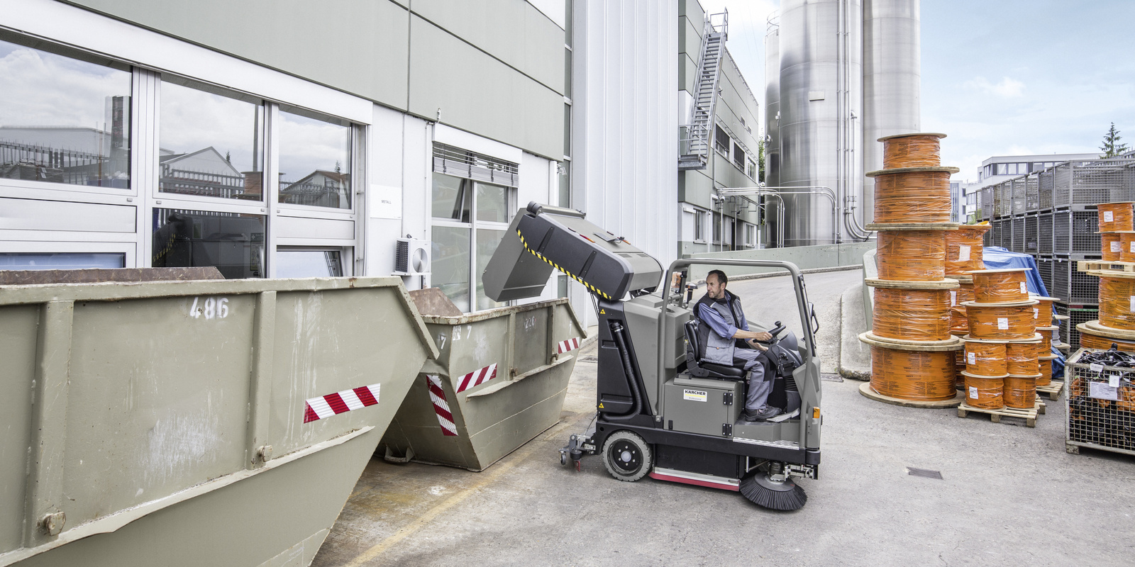 The vacuum sweeper machine in use The container of a vacuum sweeper is being emptied