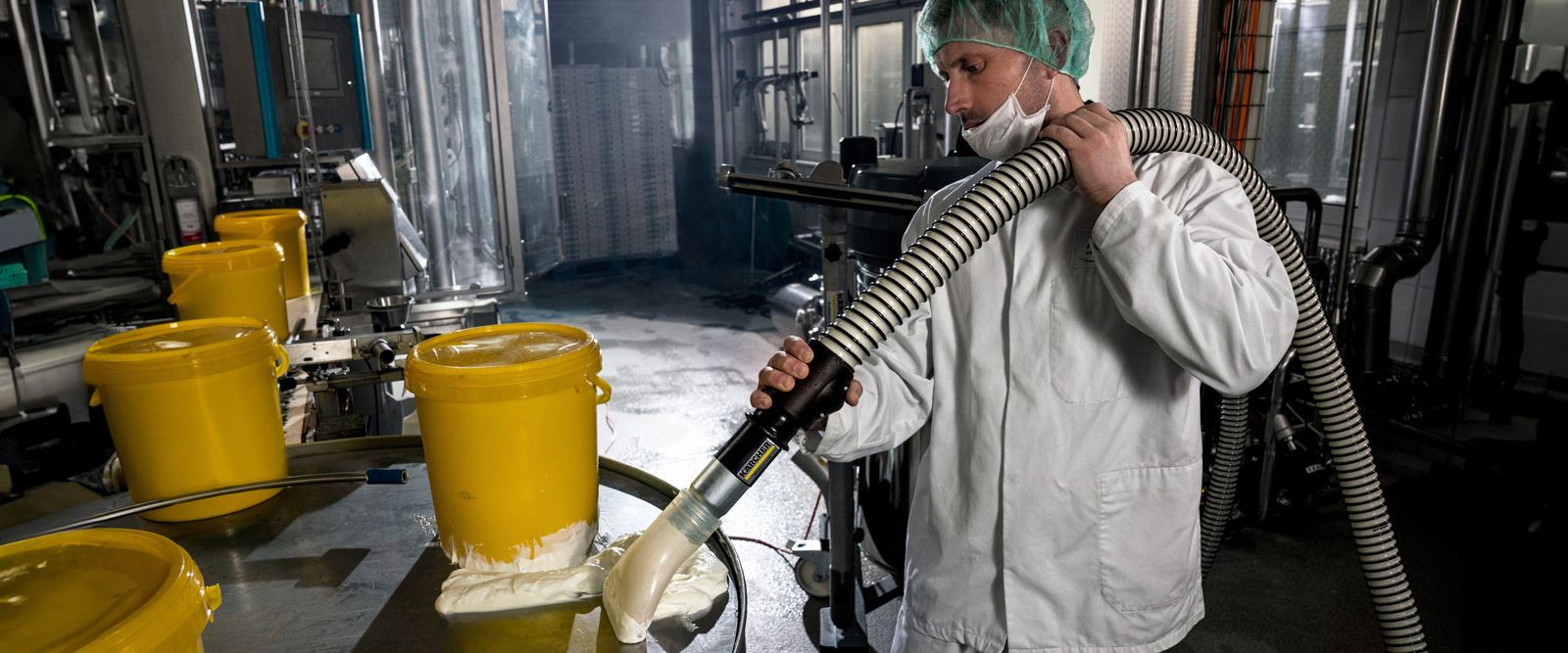 Industrial vacuum cleaner in use A man vacuums particles with the industrial vacuum cleaner