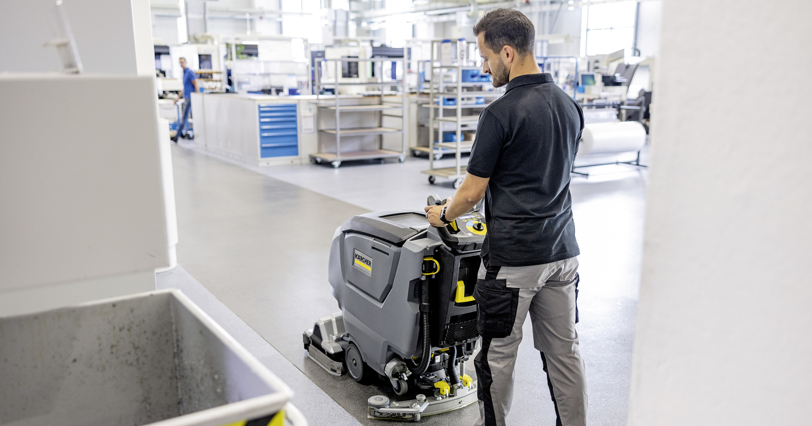 Cleaning with a walk-behind scrubber-dryer A man cleans the floor with a Kärcher walk-behind scrubber-dryer