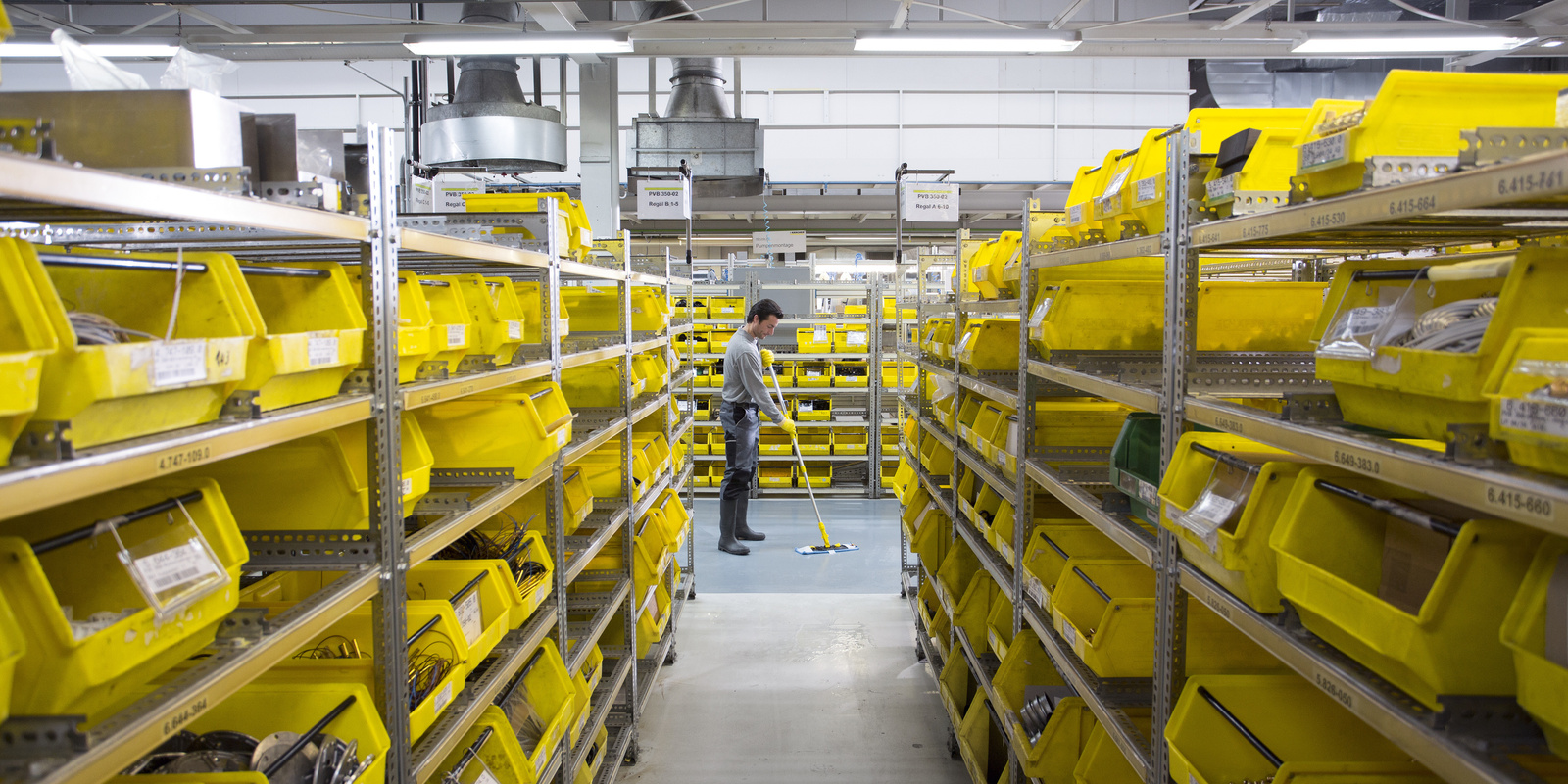 Manual floor cleaning in the warehouse A man manually cleans the floor in the warehouse