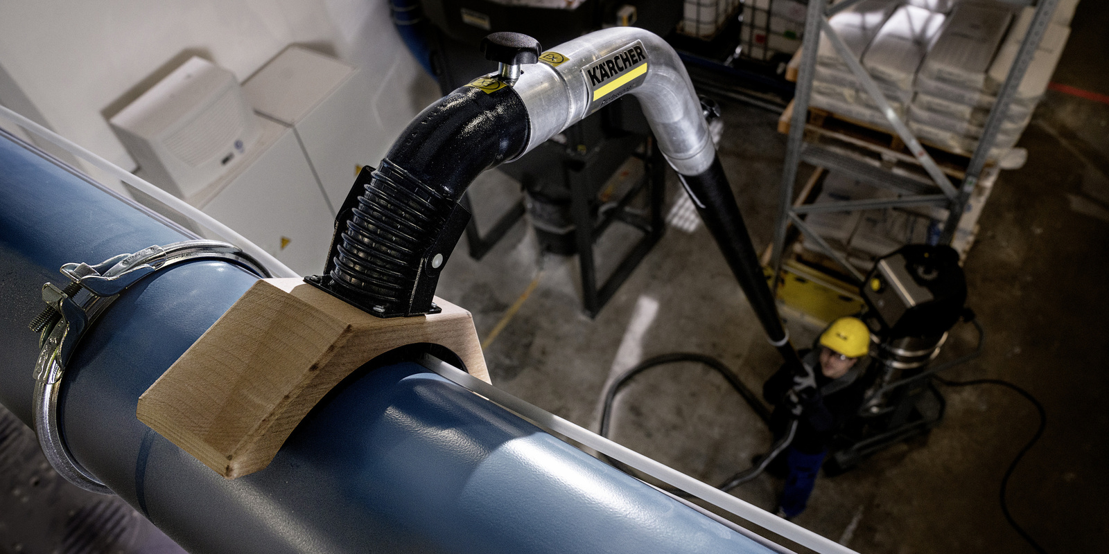 Industrial vacuum cleaner with telescopic tube A person cleans a pipeline with the industrial vacuum cleaner with a telescopic tube