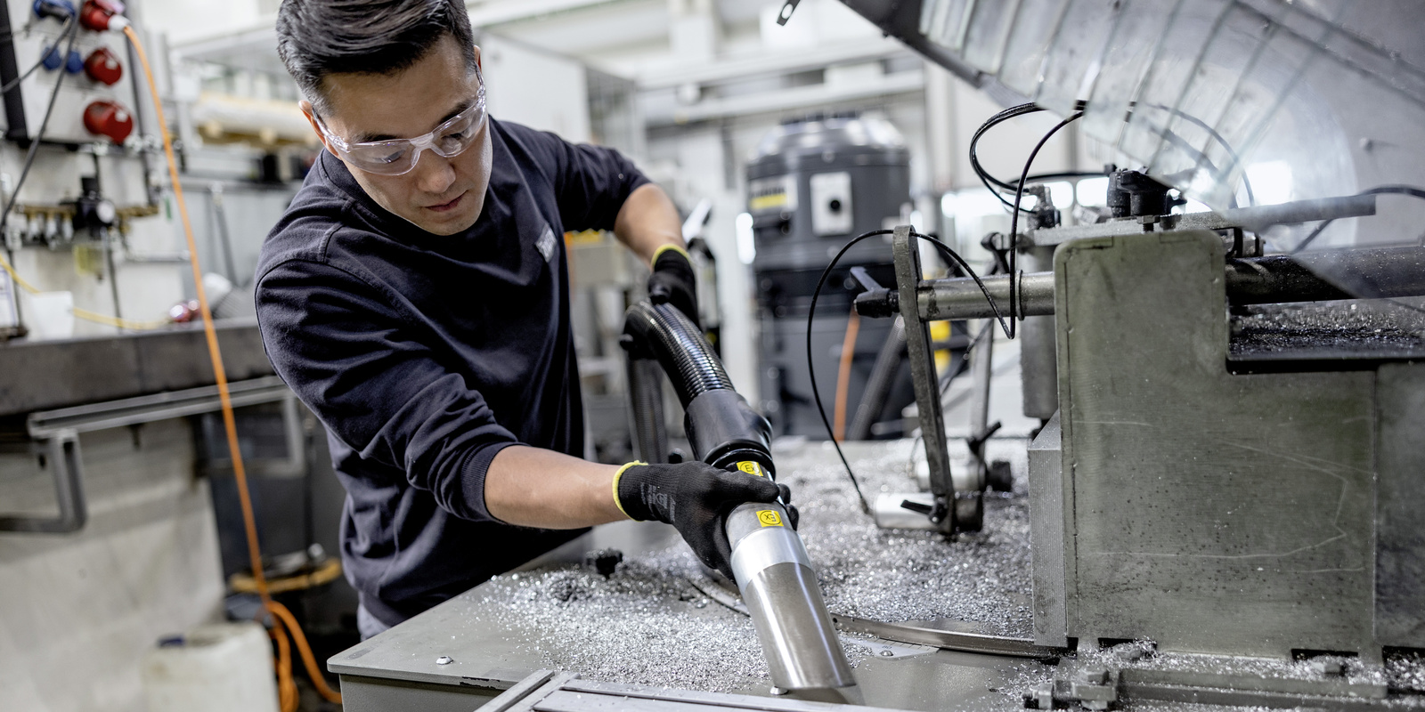 Removing metal shavings with a mobile extraction unit A man vacuums metal shavings with a mobile extraction unit