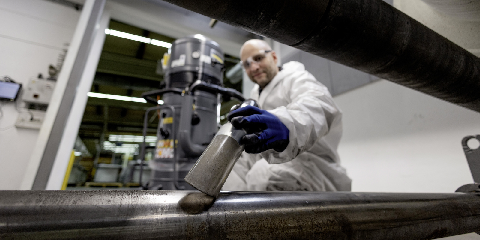 Cleaning in industry with an extraction unit A person operates a Kärcher extraction unit