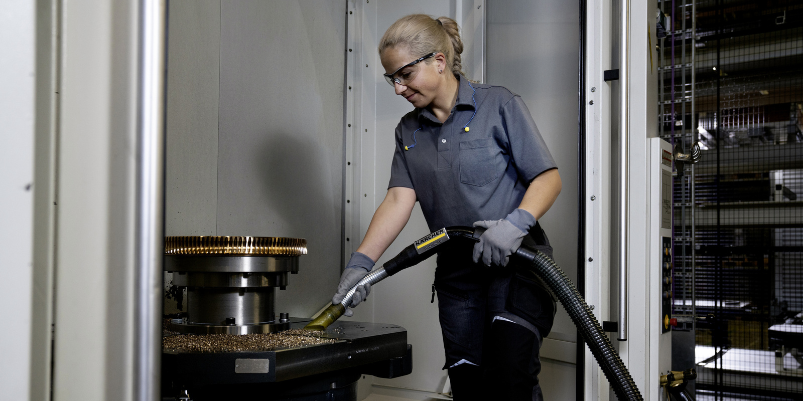 Vacuuming greasy metal shavings in the metal industry A woman vacuums greasy metal shavings