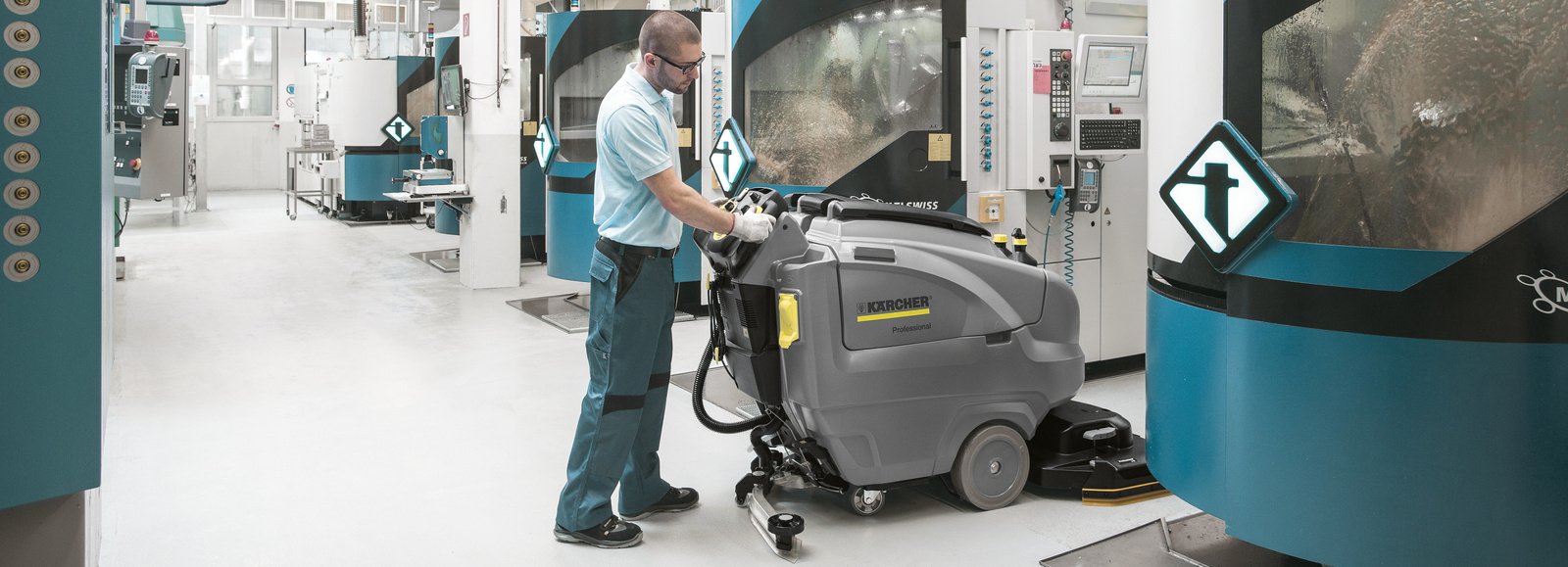 Floor cleaning in the production hall with a scrubber-dryer A man cleans the floor in the production hall with a scrubber-dryer