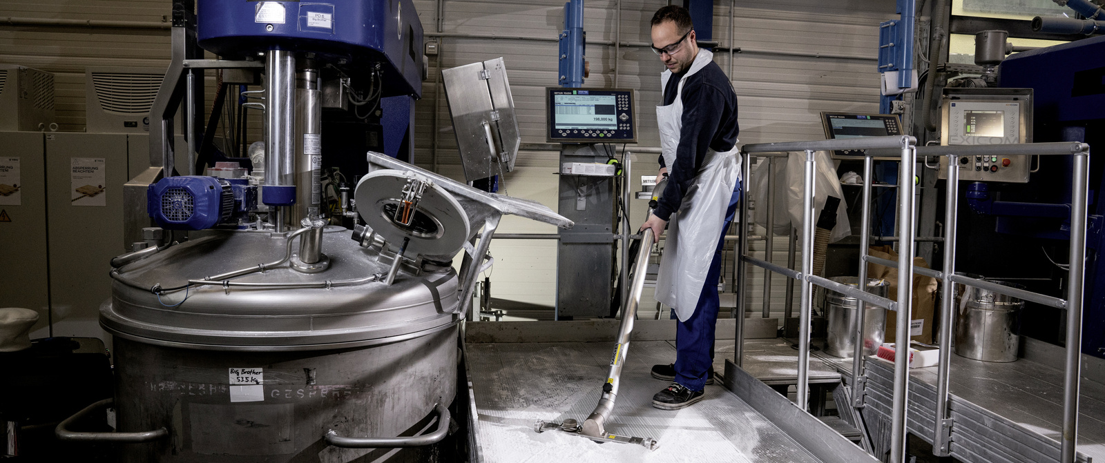 Vacuuming dirt particles in the production area A man vacuums dirt particles in the production area