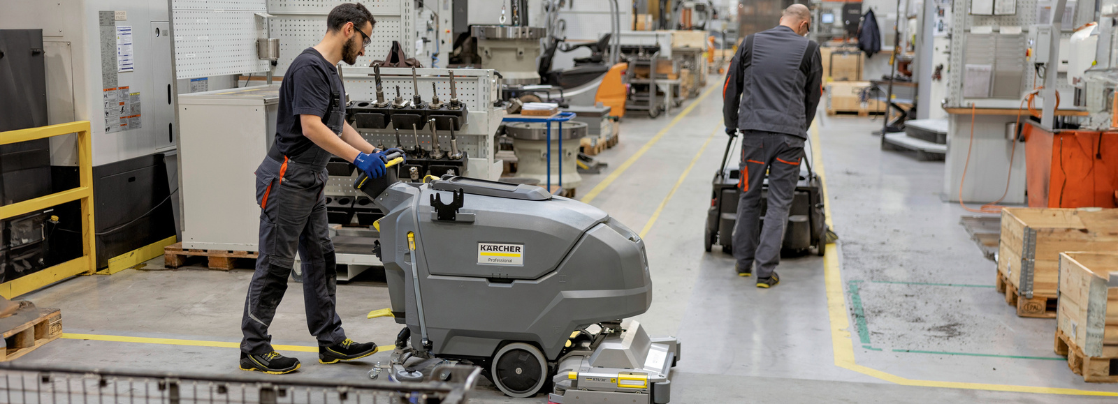 Professional floor cleaning in a production facility Two people clean the floor in a production facility