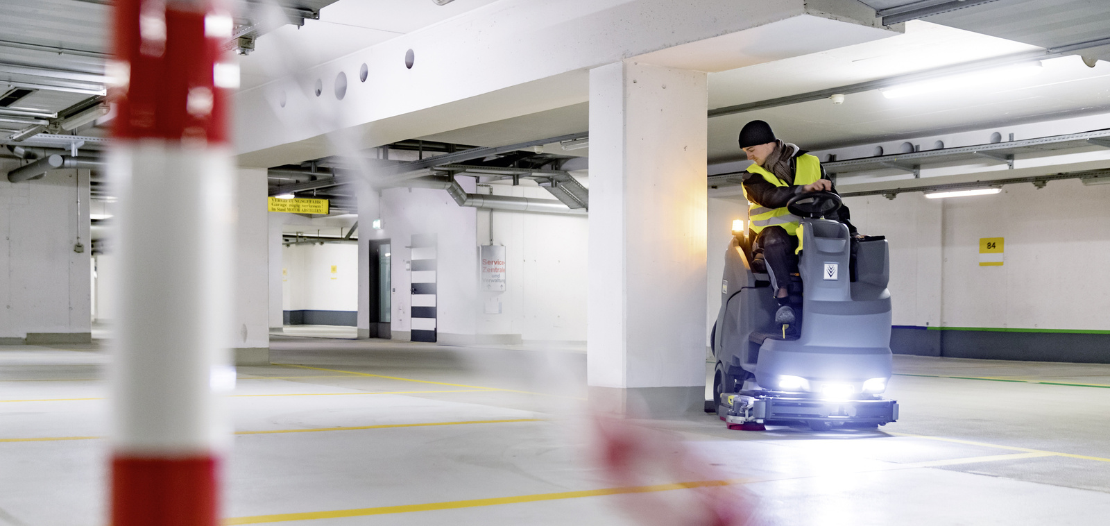 A person operating a ride-on sweeper