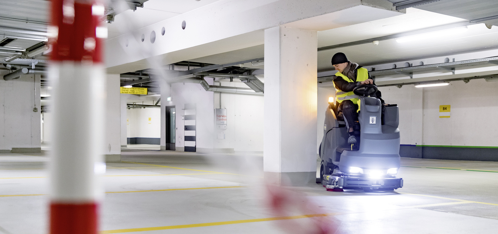 Cleaning car parks A person sits on a ride-on sweeper and cleans a parking garage