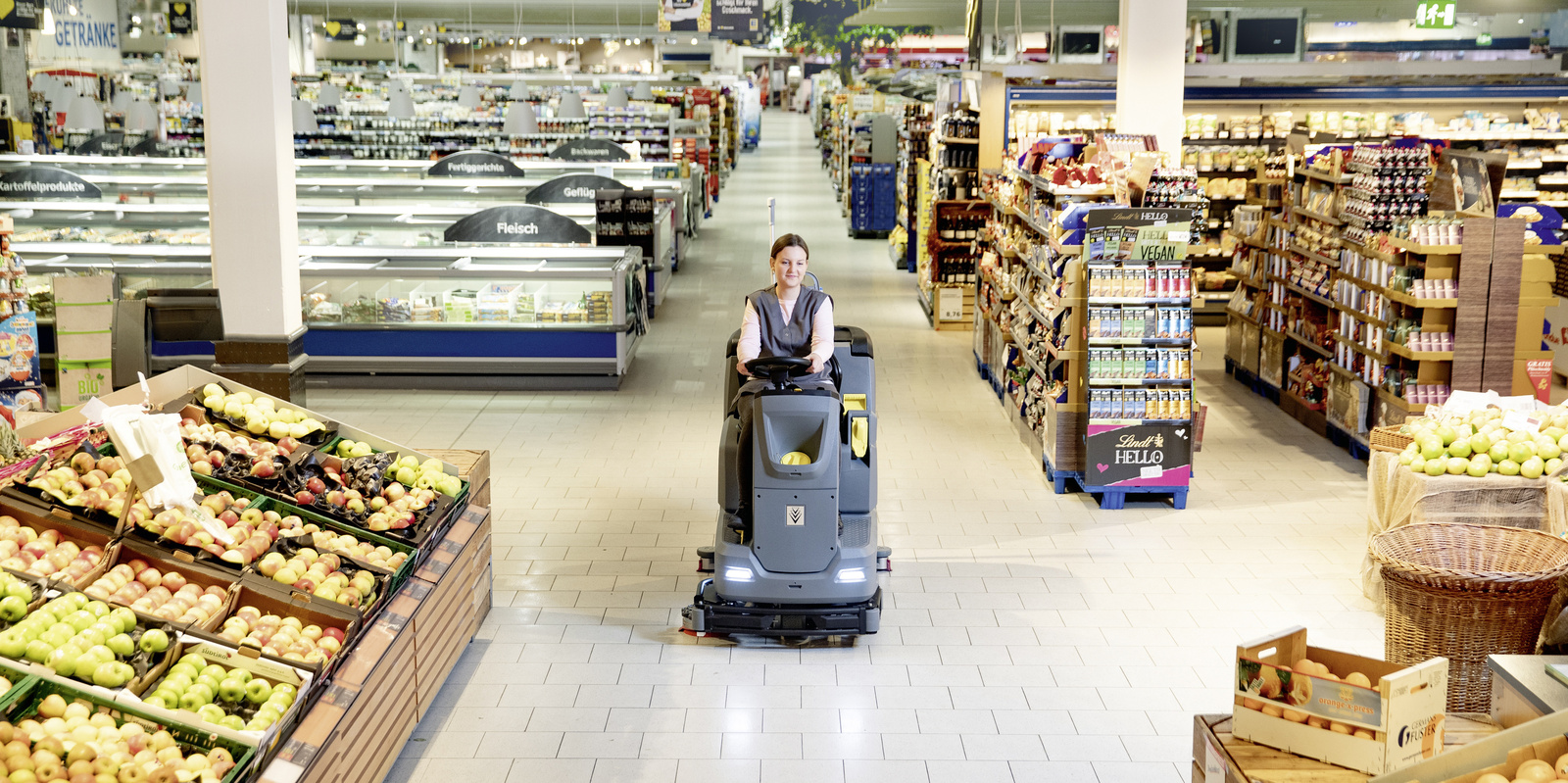 Cleaning supermarkets A person is cleaning the floor area of a supermarket with a scrubber dryer