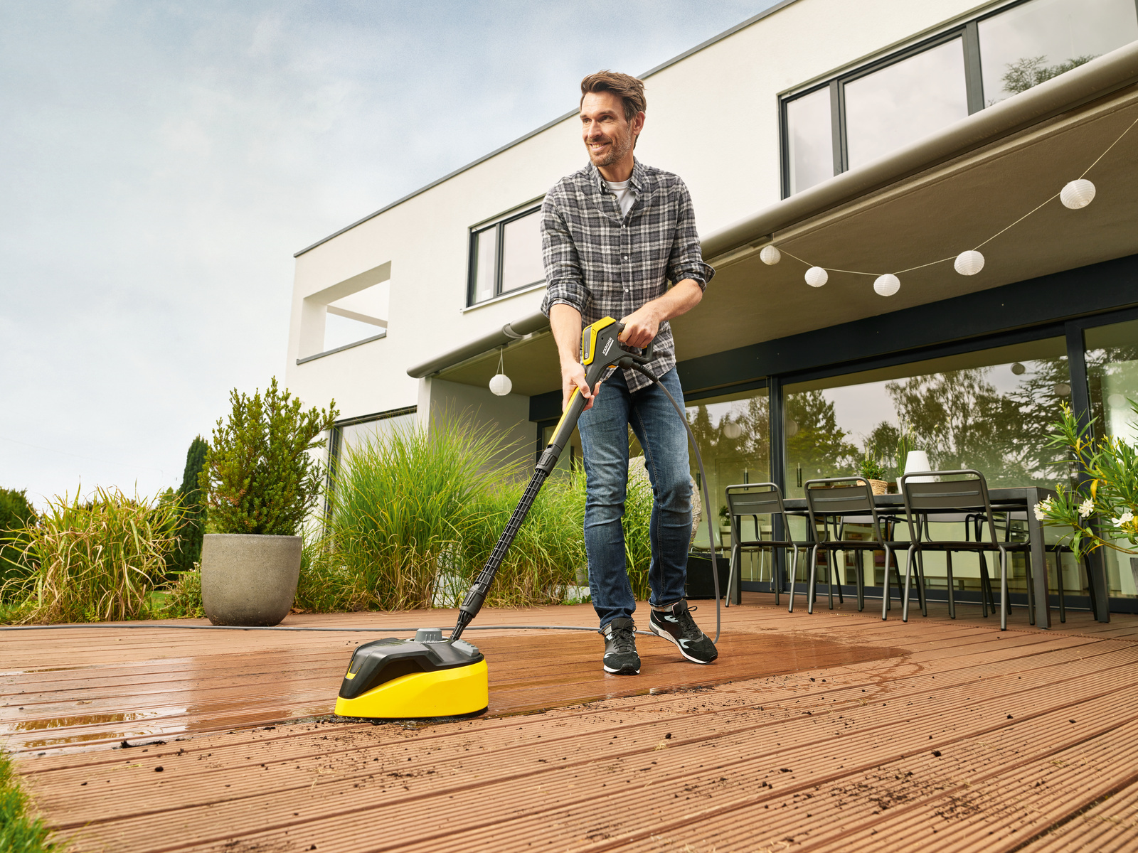 Nettoyer une terrasse en bois Un homme nettoie sa terrasse en bois