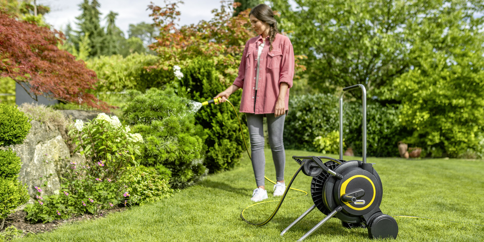 A man is watering flowers in the garden