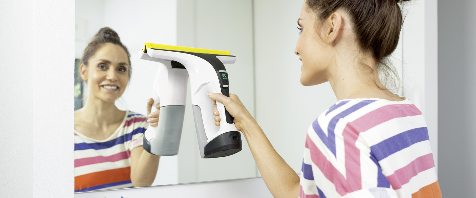 Cleaning mirrors A woman cleaning a mirror with the Kärcher Window Vac