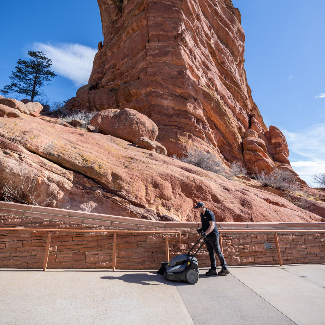 Cleaning with a walk-behind sweeper.
