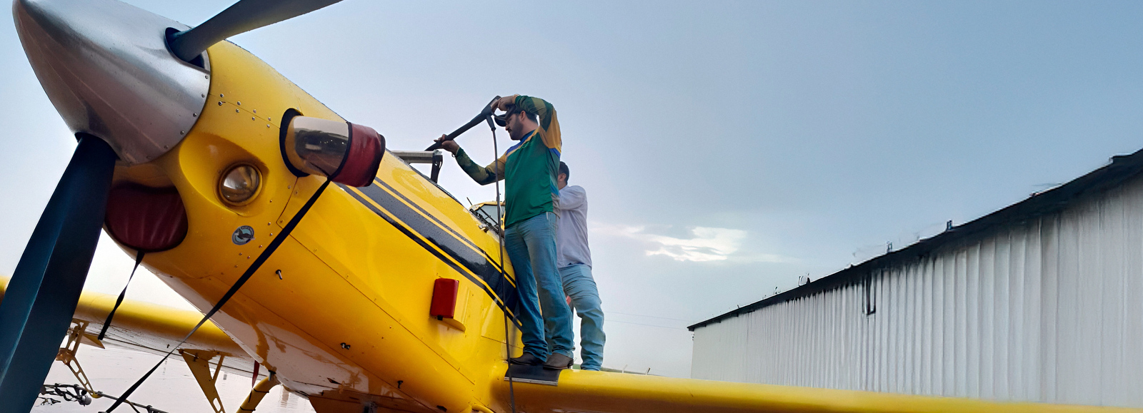 Manutenção e Limpeza de Aviões Agrícolas Profissional realizando a manutenção e limpeza de avião agrícola com lavadora de alta pressão