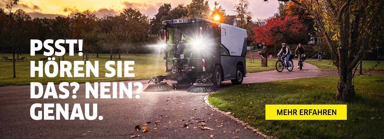 Das Bild zeigt eine leise Kehrmaschine bei Sonnenuntergang in einem Park. Während die Maschine kehrt, fahren im Hintergrund ungestört Radfahrer vorbei. Der groß geschriebene Text "PSST! HÖREN SIE DAS? NEIN? GENAU." und der gelbe Button "MEHR ERFAHREN" betonen die geringe Geräuschentwicklung des Geräts und laden zur Informationsbeschaffung ein.