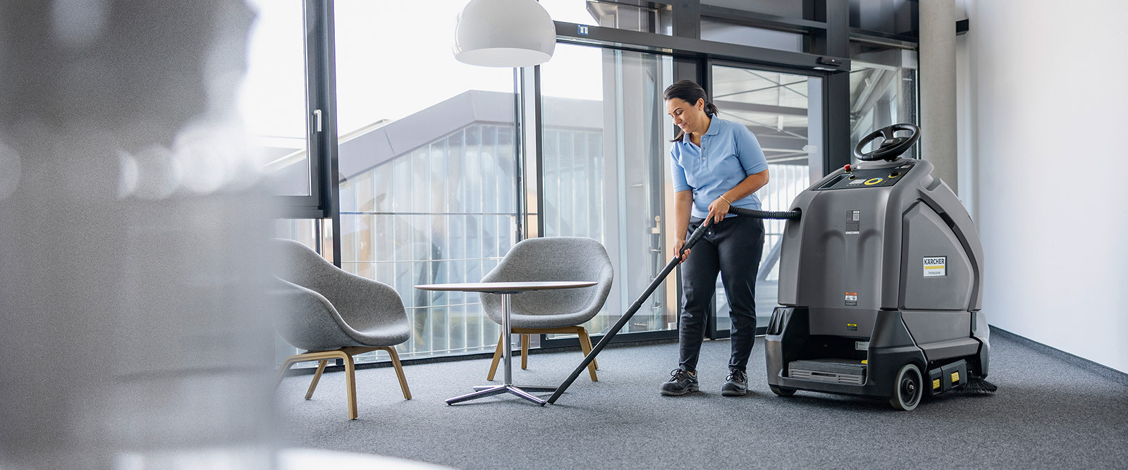 A worker vacuums office carpets with the Kärcher KIRA CV 60/1 autonomous vacuum cleaner