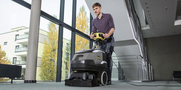 Kärcher Walk-Behind Carpet Extractors A worker uses a Kärcher Armada® BRC 45/38 walk-behind carpet extractor in a commercial building hallway