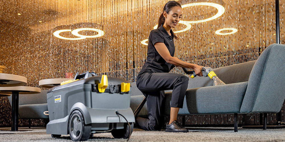 Extractors for hotels and catering A worker cleans hotel furniture with a Kärcher Puzzi 10/1 compact extractor
