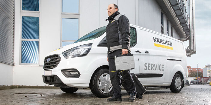 Kärcher Equipment Services A Kärcher Services Tech walks next to his service van