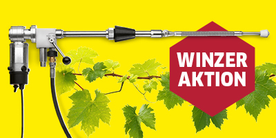 Aktion für Winzer  Das Bild zeigt eine horizontale Werbeanzeige mit einem leuchtend gelben Hintergrund. Im Vordergrund sind Reben und grüne Weinblätter zu sehen, die von der linken unteren Ecke diagonal nach oben zur Mitte des Bildes verlaufen.  Auf der linken Seite des Bildes ist eine silberne, industrielle Ausrüstung abgebildet, die aussieht wie eine Sprühlanze oder ein Werkzeug mit einem Griff und einem längeren Rohr. Ein schwarzer Schlauch ist unten an dem Gerät angebracht.  In der rechten Hälfte des Bildes befindet sich eine große, rote, sechseckige Form, die wie ein Wappen aussieht. Darauf steht in weißen, versalen Buchstaben der Text "WINZER AKTION".  Das gesamte Bild scheint für Winzer oder Weinbauern zu werben und kombiniert die landwirtschaftlichen Elemente des Weinbaus mit einem speziellen Werkzeug oder Angebot.