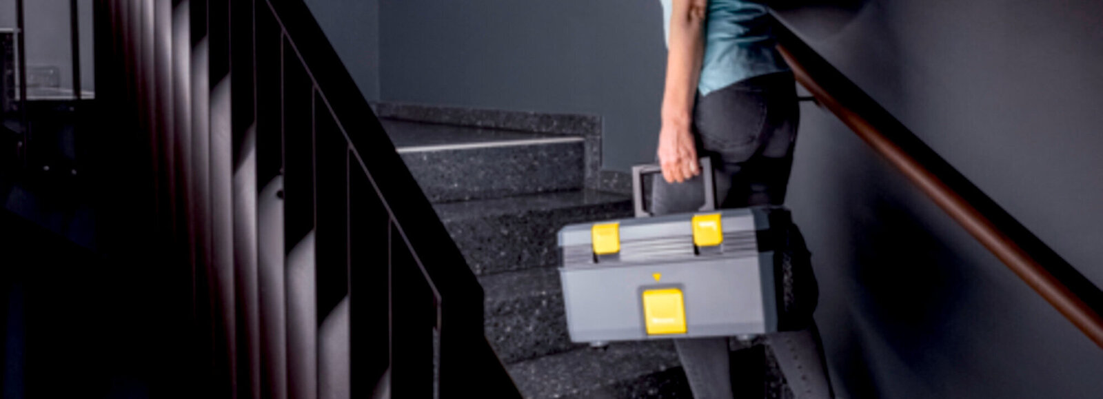 A person cleaning the barefoot area of a changing room with a steam vacuum cleaner