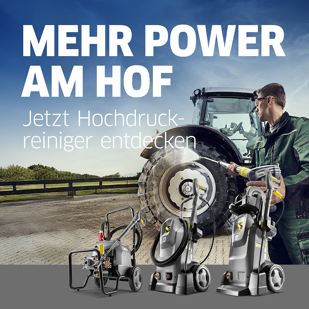 Das Bild zeigt einen Mann der mit einem Hochdruckreiniger einen Traktor reinigt.