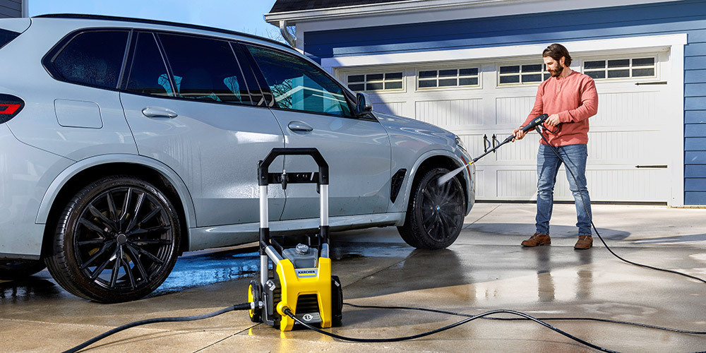 A man cleans his car using a Kärcher Home & Garden pressure washer