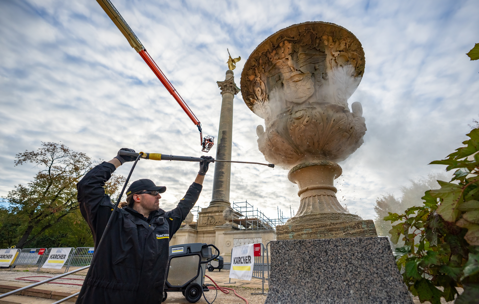 Man Pressure Washing Limestone Statue of Urn