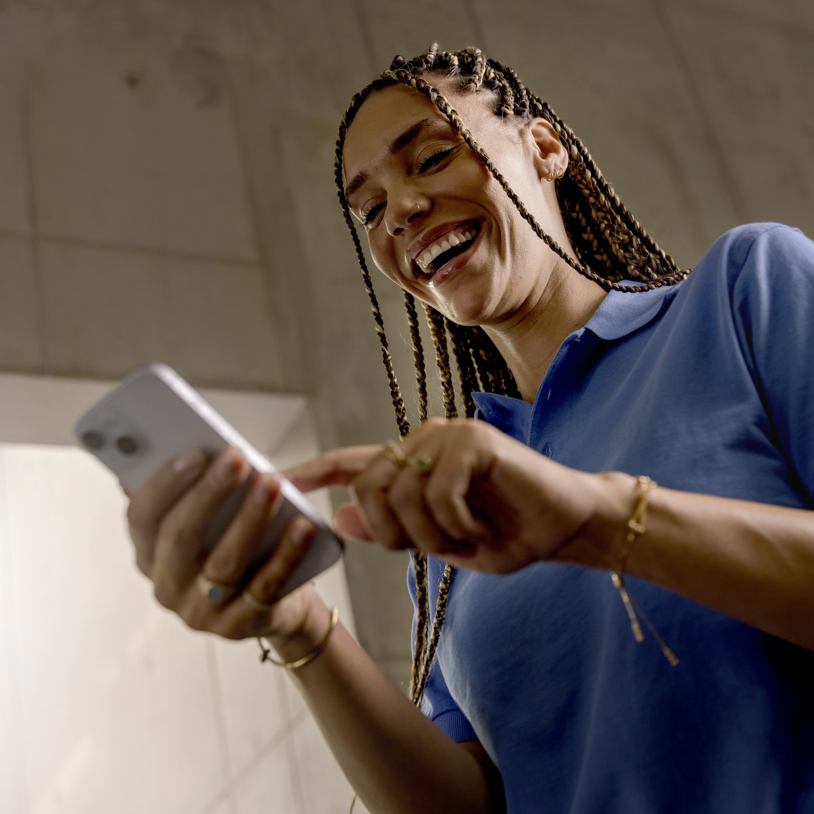Einfach nutzbare Handy-App für Ihr Reinigungsteam: Connected Cleaning Lächelnde Reinigungskraft nutzt Connected Cleaning App auf Ihrem Handy