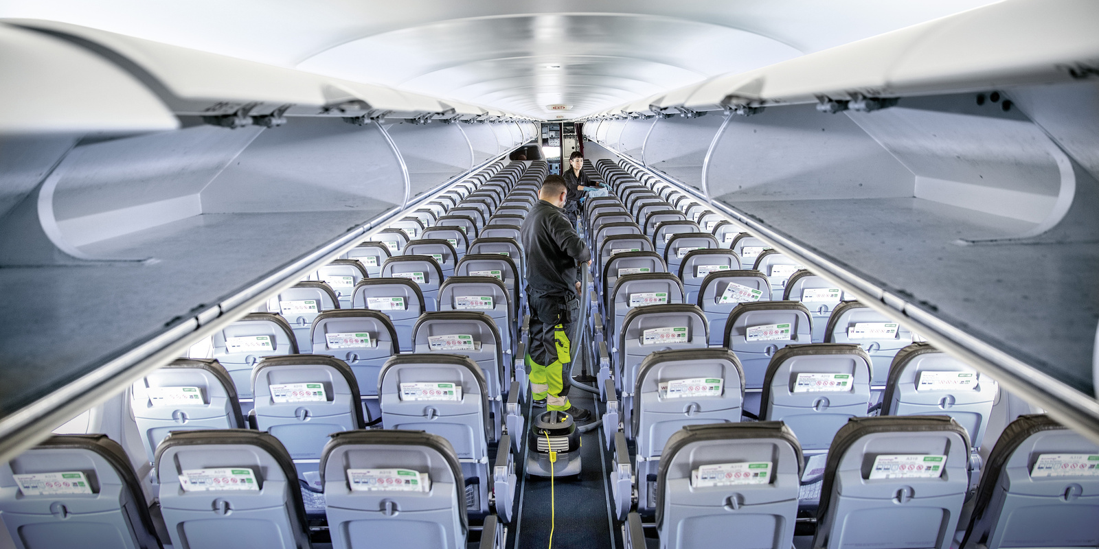 Workers clean inside an airplane using Kärcher commercial floor cleaning equipment