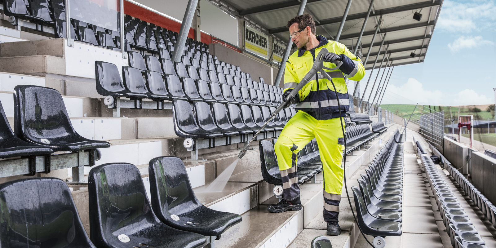 A worker cleans the concrete steps in a sports arena