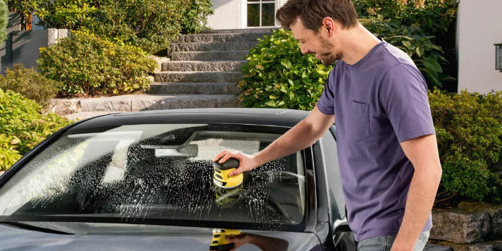 Kärcher: Autopflege - Mann reinigt sein auto mit einem Tuch