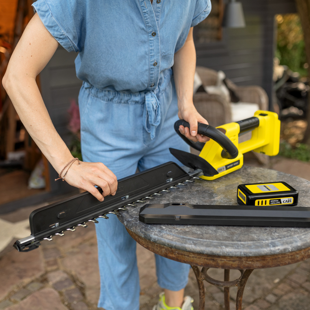 one hand demonstrates the working principle of the hedge broom of the Kärcher battery hedge trimmer