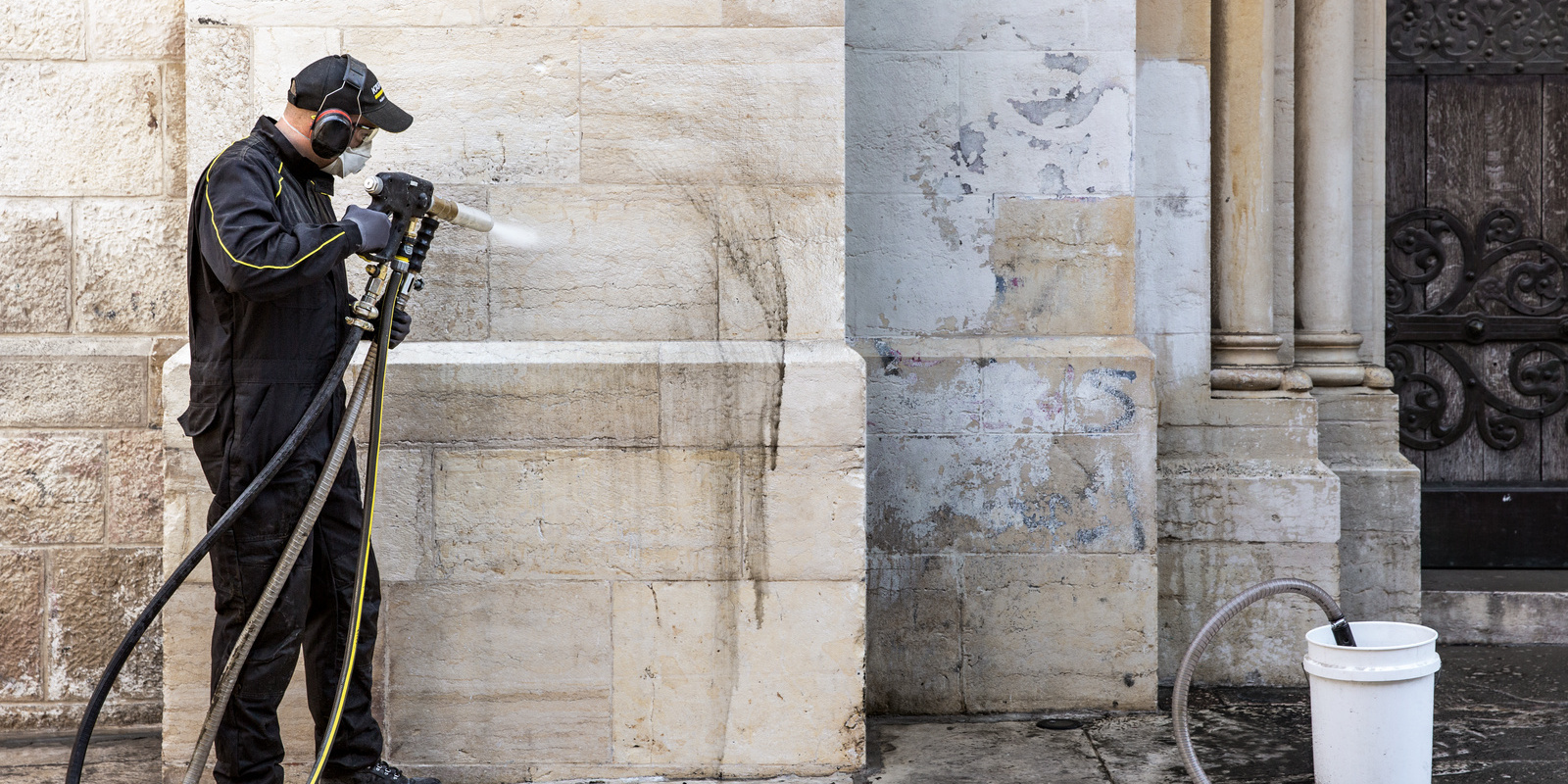 ein Mann reinigt einen Gerüstboden mit einem Kärcher Hochdruckreiniger