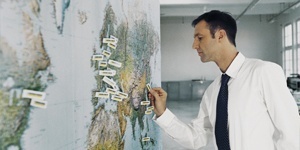 A Kärcher employee adds flag pins to a world map