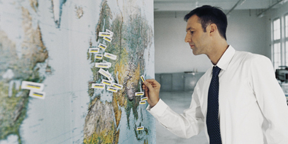 A Kärcher employee pushes pin flags in a world map