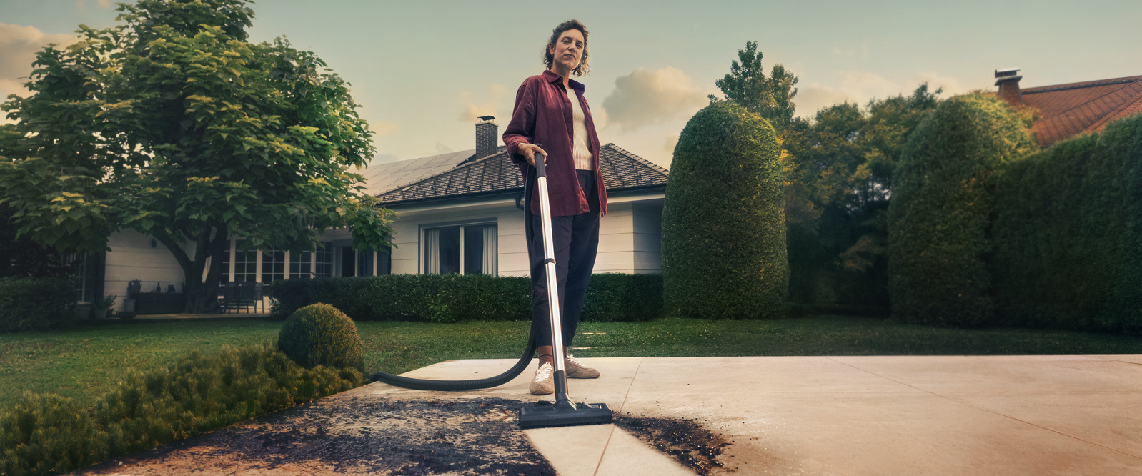 Person cleaning patio using Kärcher wet and dry vacuum cleaner