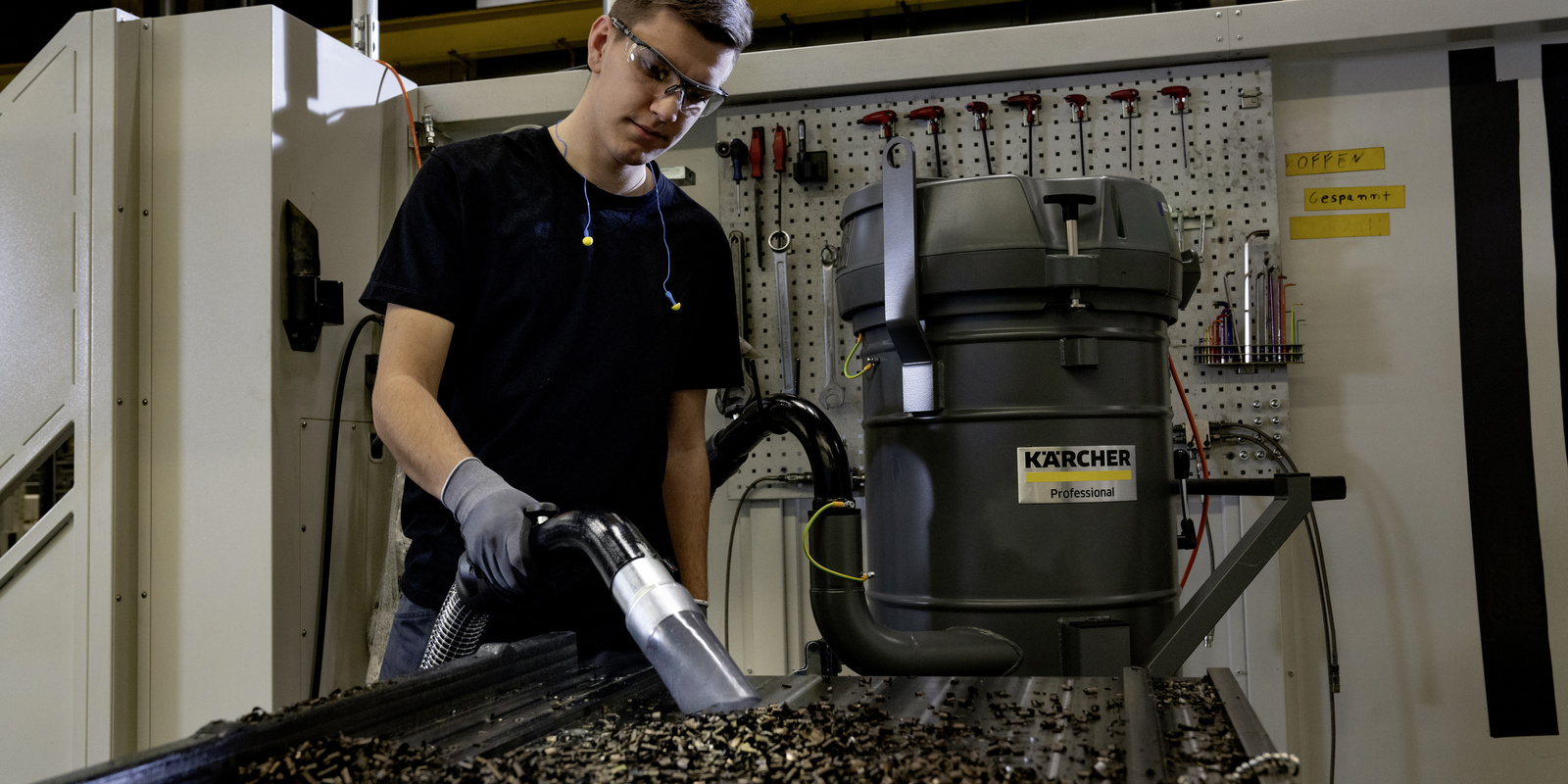 Operario utilizando la aspiradora industrial robusta Kärcher IVR para la recolección de residuos en la industria metalmecánica.