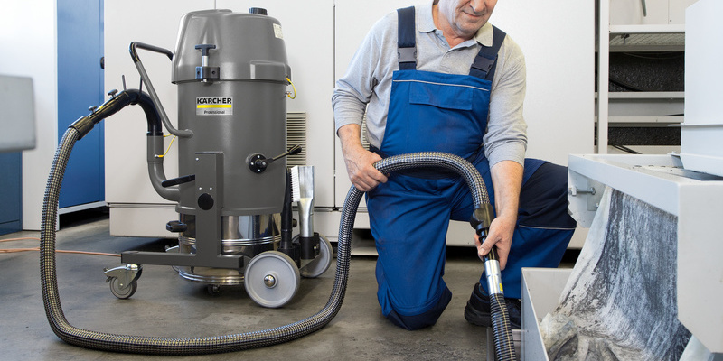 Ein Mann, der Staub saugt Das Kärcher Industriesystem