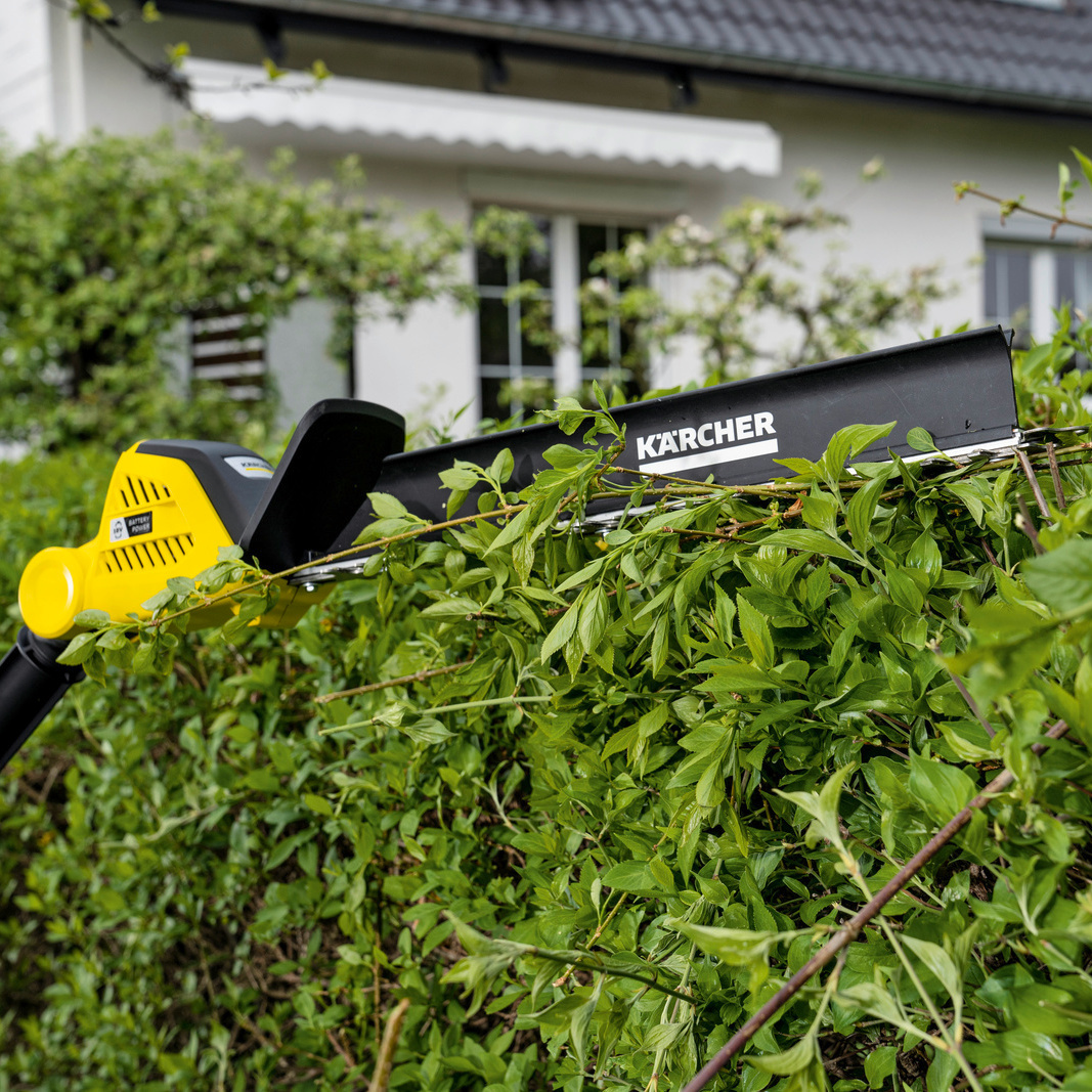 Teleskop-Heckenschere: Schnittgutkehrer die Kärcher Akku-Heckenschere mit Schnittgutkehrer im Einsatz an einer Hecke