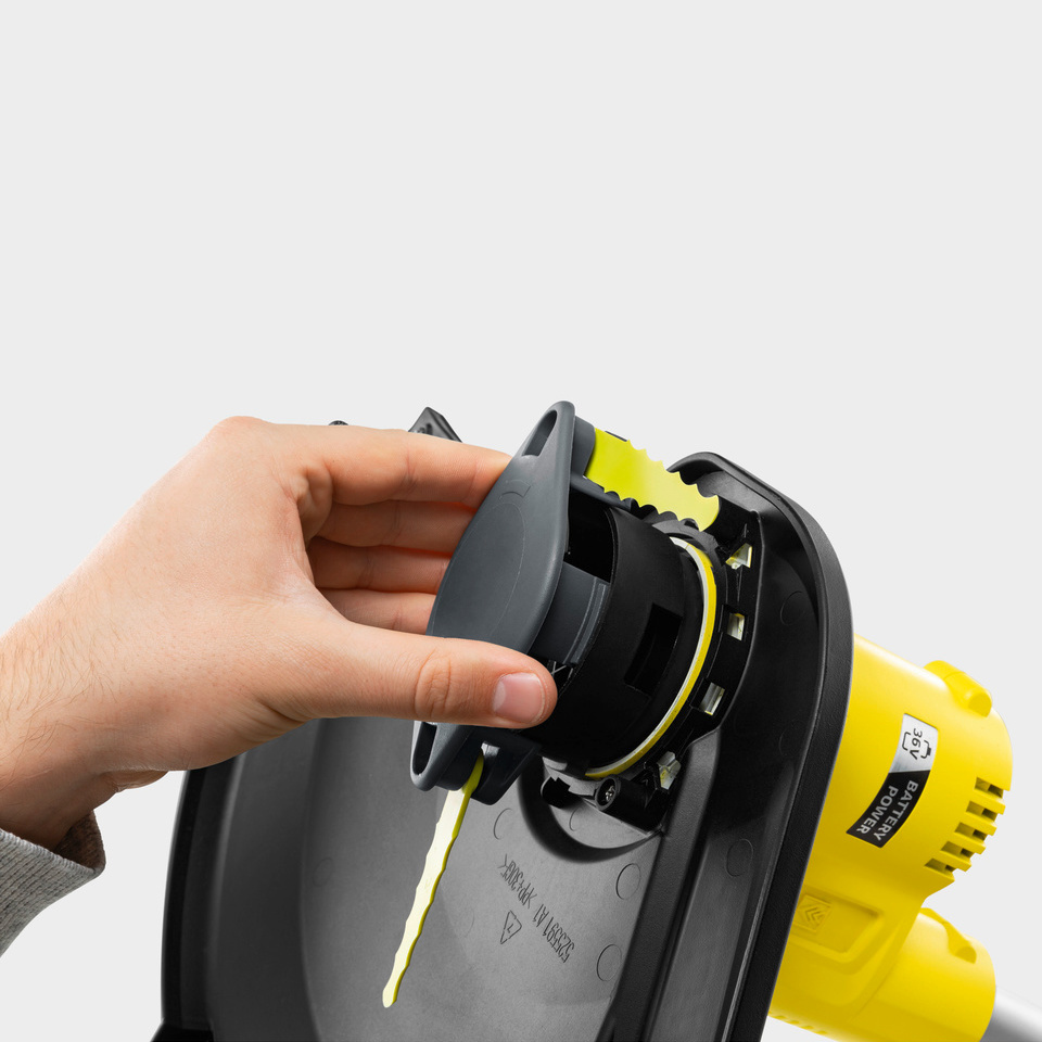Einsatz von Trimmermessern Eine Hand installiert Trimmermesser am Kärcher Akku-Rasentrimmer